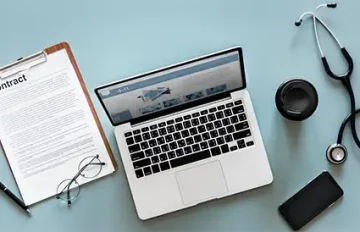 Is NEN 7510 verplicht? Laptop, contract, stethoscoop, koffie